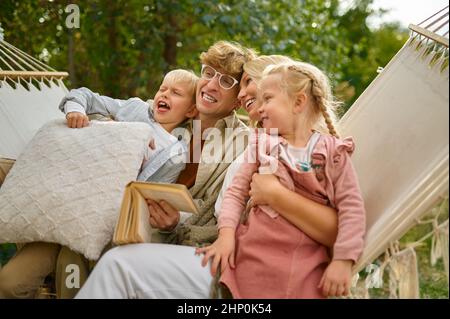 Famille gaie s'amuser sur hamac, camping d'été.Couple avec enfants voyage dans la voiture de camp, la nature et la forêt en arrière-plan.Camping aventure, t Banque D'Images