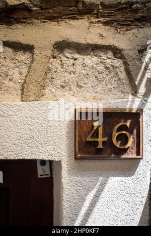 Plaque numéro 46 sur un mur sale de la vieille maison. Banque D'Images