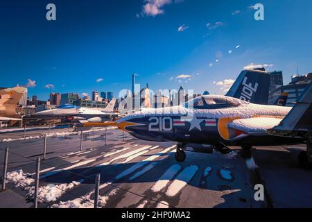 Vue d'un avion de chasse F-9 Cougar sur le pont de vol de l'USS Intrepid Sea, Air and Space Museum en face de l'horizon de Manhattan, New York, NY, USA Banque D'Images