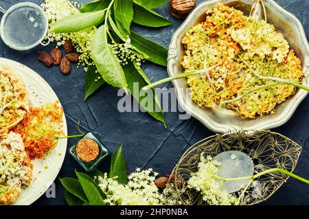 Sureau frit en pâte avec sucre en poudre.Dessert floral printanier Banque D'Images