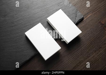 Photo de deux piles de cartes de visite vierges sur fond de panneau de pierre. Banque D'Images