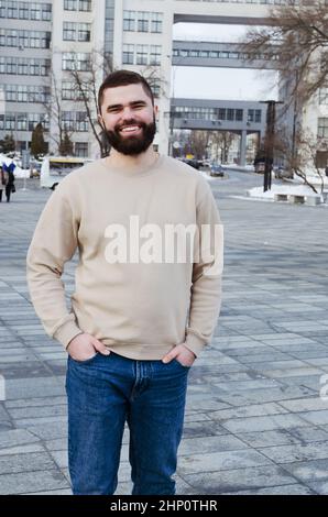 jeune homme d'affaires élégant en hiver décontracté vêtements, veste, chapeau. Marcher dans la rue de la ville, parler au téléphone, faire le selfie. Travailler à l'extérieur. Banque D'Images