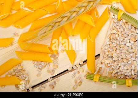 Les pâtes italiennes courtes penne avec grains de blé dur Banque D'Images