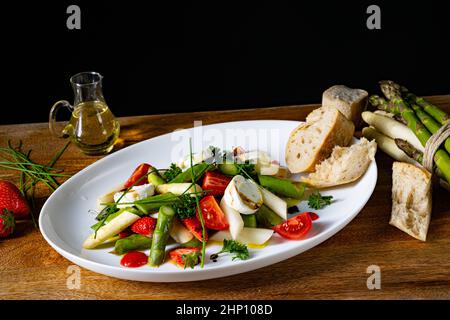 Salade d'asperges avec fraises, tomates et fromage de chèvre Banque D'Images