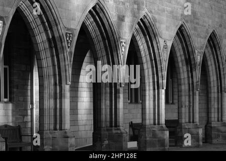 Une photographie en noir et blanc des arches en pierre et de la passerelle cloisonnée qui font partie de Elphinstone Hall, Aberdeen University, Aberdeen, Écosse. Banque D'Images