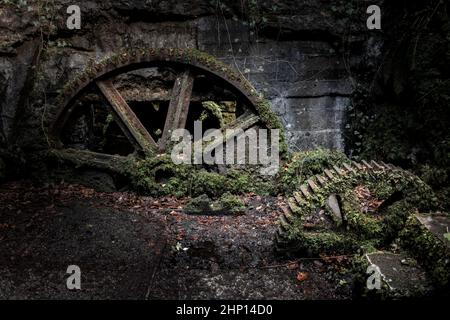 Vue rapprochée des grandes roues rouillées à l'intérieur des vestiges historiques d'un moulin à eau utilisé dans la fabrication de poudre à canon dans la vallée de Kennall Banque D'Images