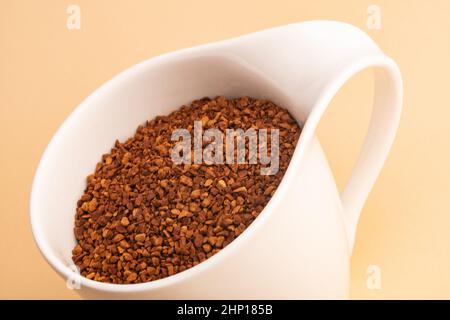 Café en poudre dans une belle tasse de café sur fond beige Banque D'Images