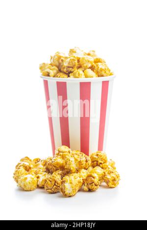 Pop-corn au caramel sucré dans une tasse en papier isolée sur fond blanc. Banque D'Images