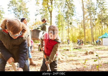 Les enfants du centre de garde de jour de la forêt plantent des arbres dans le cadre d'une campagne de conservation de la nature pour le reboisement dans la forêt Banque D'Images