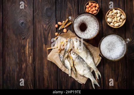 Alcool de bière lager et pinte de stout, bière artisanale. Deux verres de bière avec mousse et en-cas sur un fond rustique en bois. Traditionnel allemand Wha Banque D'Images