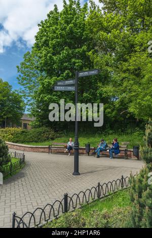 Kaliningrad, Russie - 18 mai 2021 : les gens se détendent au printemps sur les bancs de la petite place avec un point de repère Banque D'Images