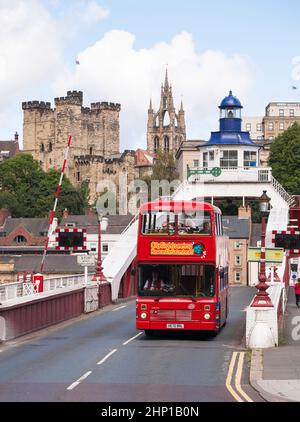 Visite de la ville en bus traversant le pont tournant avec le château et la cathédrale de Newcastle en arrière-plan, nord-est de l'Angleterre, Royaume-Uni Banque D'Images