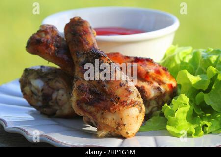 Repas d'été. Idées pour barbecue, fête au grill. Cuisses de poulet avec sauce barbecue grillées, frites au feu . Banque D'Images