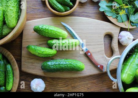 Concombres marinés fermentés, aneth, ail sur table en bois. Banque D'Images