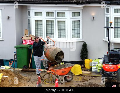 Un constructeur utilisant un mélangeur de ciment à l'extérieur d'une maison privée en cours de construction, Shepperton Surrey Angleterre Royaume-Uni Banque D'Images