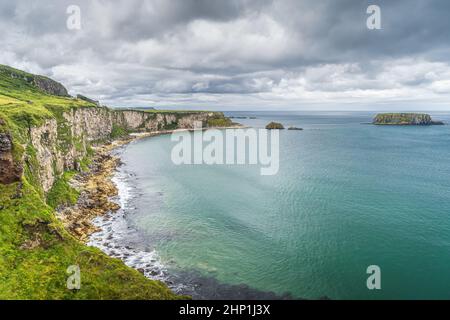 Côte avec de hautes falaises de calcaire, l'île de Sheep et l'océan Atlantique turquoise, près du pont de corde de Carrick a Rede, Wild Atlantic Way, Irlande du Nord Banque D'Images