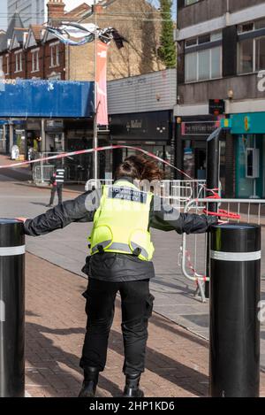 Southend on Sea, Essex, Royaume-Uni. 18th févr. 2022. Storm Eunice a atteint Southend on Sea, causant des dommages aux bâtiments de High Street et ses environs. Les Street Rangers essaient de garder les gens à l'écart. Une fenêtre écrasée au-dessus a fait tomber du verre dans la rue. Des sections de High Street ont depuis été fermées à la suite de blessures au public. Une femme agent de sécurité communautaire se pavane contre les vents violents en utilisant des bornes pour s'ancrer Banque D'Images