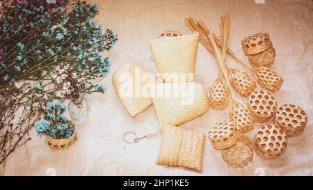 Ensemble de panier en osier vide sur la table avec fond en lin naturel et plante verte, maquette de modèle pour la présentation du produit Banque D'Images