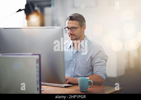 Pour faire les choses, un clic à la fois. Photo courte d'un homme d'affaires travaillant à son bureau. Banque D'Images