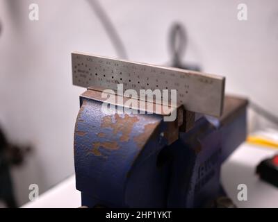 Étau tenant une plaque de tirage en fil dans un atelier de bijoux Banque D'Images