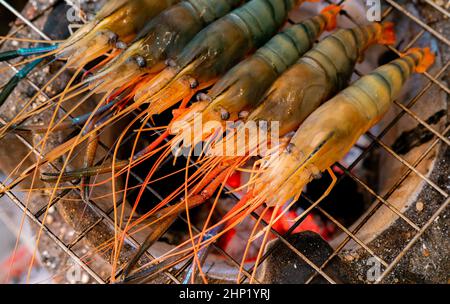 Crevettes grillées sur un grill au charbon de bois.Des crevettes géantes d'eau douce grillent sur un feu de charbon de bois flamboyant.Gros plan sur la cuisson de crevettes géantes sur le grille-barbecue.C Banque D'Images