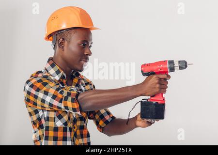 African American construction worker in casque utilise tournevis électrique Banque D'Images