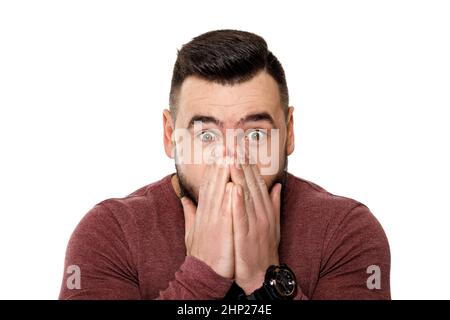 l'homme choqué couvre son visage avec ses mains sur fond blanc. Banque D'Images