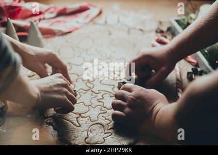 Joyeux Noël, Bonne Année. Cuisson de pain d'épice, cuisson. Maman et fille font des biscuits, découpez différentes formes de biscuits en utilisant la coupe de métal M. Banque D'Images
