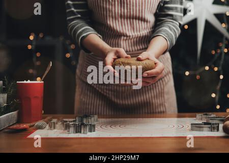 Joyeux Noël, Bonne Année. Cuisson au pain d'épice, gâteau, biscuit ou strudel. La femme en tablier pétrit la pâte. Fille tenant doucement, faux plis, Banque D'Images