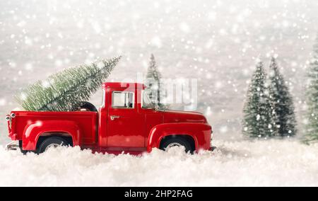 Vieux pick-up rouge d'occasion avec un sapin sur le lit, image de concept de saison, arbre de Noël, scène d'hiver Banque D'Images