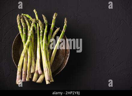 Tiges d'asperges crues. Arrière-plan sombre. Placer pour le texte. Banque D'Images