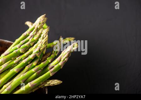 Tiges d'asperges crues. Arrière-plan sombre. Placer pour le texte. Banque D'Images