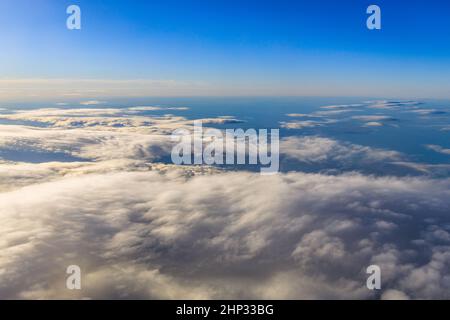 ciel bleu et nuages vus à travers la fenêtre de l'avion. Banque D'Images