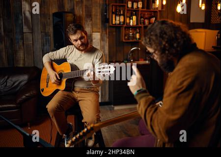 Professeur de musique joue de la mélodie sur guitare électrique pour un étudiant de sexe masculin.Cours de maître personnel de formation de leçon Banque D'Images