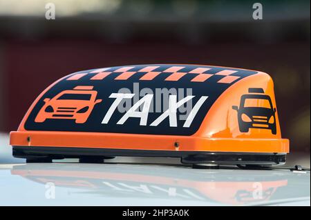 un panneau de taxi orange se trouve sur le toit de la voiture. Photo de haute qualité Banque D'Images