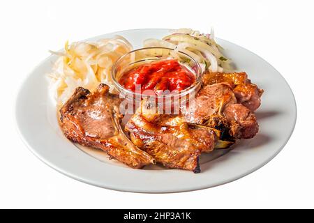 un kebab d'agneau sur un os repose sur une assiette sur un fond blanc isolé. Photo de haute qualité Banque D'Images