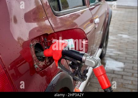 le pistolet est inséré dans le réservoir de gaz de la voiture. Photo de haute qualité Banque D'Images