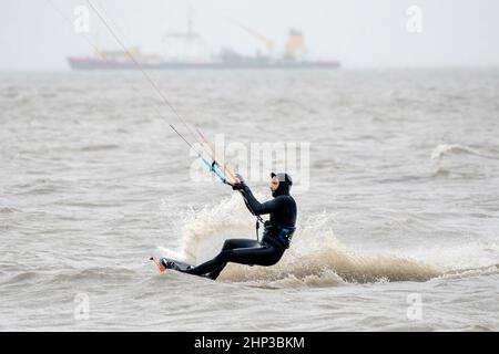 Schillig, Allemagne. 18th févr. 2022. Un kitesurfer est sur la mer du Nord par temps orageux. Après une courte hauteur intermédiaire, l'ouragan 'Zeynep' devrait traverser la Basse-Saxe depuis l'ouest au cours de la journée. Credit: Hauke-Christian Dittrich/dpa/Alay Live News Banque D'Images