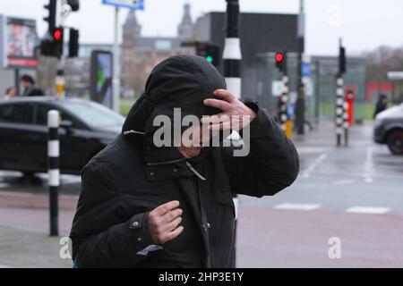 Amsterdam, pays-Bas. 18th févr. 2022. Une femme lutte contre les vents forts marche dans la rue près de Museumplein le 18 février 2022 à Amsterdam, pays-Bas. Le bureau météorologique néerlandais de KNMI a émis un code rouge d'avertissement météorologique pour la côte et l'orange pour le reste du pays, les transports publics, les services de trains internationaux et plus de 165 vols à partir de l'aéroport de Schiphol ont été annulés à partir de 2pm. (Photo de Paulo Amorim/Sipa USA) Credit: SIPA USA/Alay Live News Banque D'Images