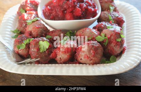 Boulettes de viande chaudes avec sauce aux canneberges sur une assiette blanche . Banque D'Images