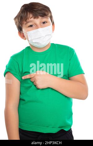 Enfant pointant sur le plâtre après la vaccination du coronavirus portant un masque facial contre le virus Corona COVID-19 Covid isolé sur un portr de fond blanc Banque D'Images