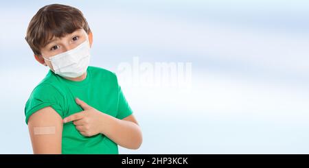 Enfant pointant sur le plâtre après la vaccination du coronavirus portant un masque facial contre le virus Corona COVID-19 Covid copyspace copy space latin Banque D'Images