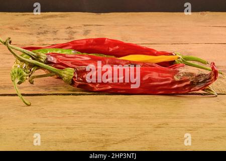 Rétrécir et mouler les piments sur fond de bois blanc. Piments pourris. Banque D'Images