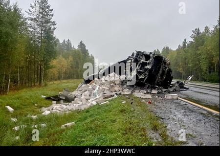 le camion brûlé se trouve sur le côté avec des blocs de béton en mousse éparpillés sur la route. Photo de haute qualité Banque D'Images