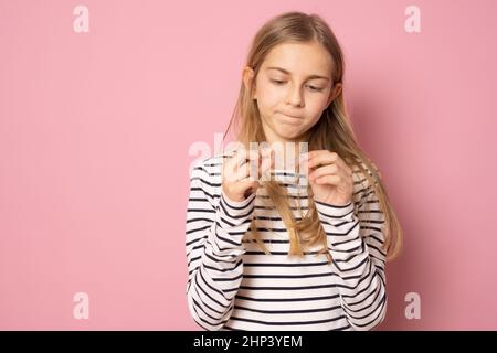 Belle jeune fille montrant un entraîneur en silicone orthodontique isolé sur fond rose. Concept dentaire. Banque D'Images