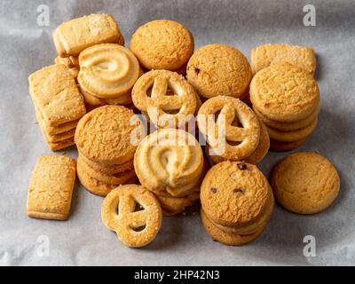 Biscuits au beurre croustillant empilés sur un parchemin blanc. Variété de biscuits sablés au sucre. Pâtisserie savoureuse. Concepts de nourriture douce. Banque D'Images