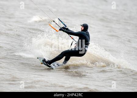 Schillig, Allemagne. 18th févr. 2022. Un kitesurfer est sur la mer du Nord par temps orageux. Après une courte hauteur intermédiaire, l'ouragan 'Zeynep' devrait traverser la Basse-Saxe depuis l'ouest au cours de la journée. Credit: Hauke-Christian Dittrich/dpa/Alay Live News Banque D'Images