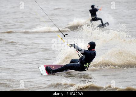 Schillig, Allemagne. 18th févr. 2022. Plusieurs kitesurfers sont sur la mer du Nord par temps orageux. Après une courte hauteur intermédiaire, l'ouragan 'Zeynep' devrait traverser la Basse-Saxe depuis l'ouest au cours de la journée. Credit: Hauke-Christian Dittrich/dpa/Alay Live News Banque D'Images