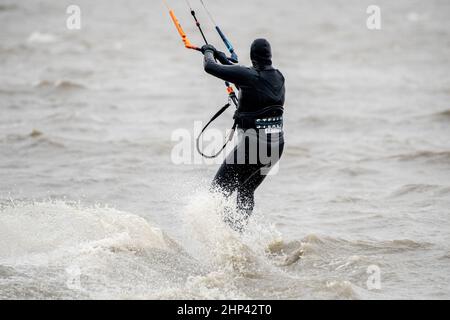Schillig, Allemagne. 18th févr. 2022. Un kitesurfer est sur la mer du Nord par temps orageux. Après une courte hauteur intermédiaire, l'ouragan 'Zeynep' devrait traverser la Basse-Saxe depuis l'ouest au cours de la journée. Credit: Hauke-Christian Dittrich/dpa/Alay Live News Banque D'Images