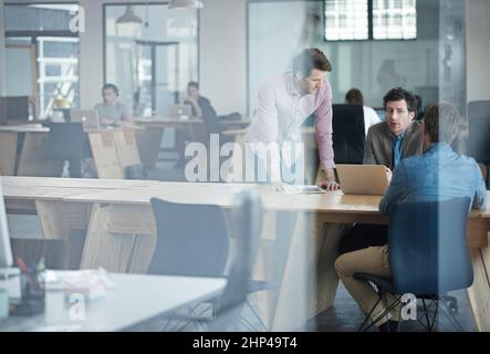 Partager des idées. Par la photo d'un groupe de collègues travaillant ensemble dans un bureau. Banque D'Images